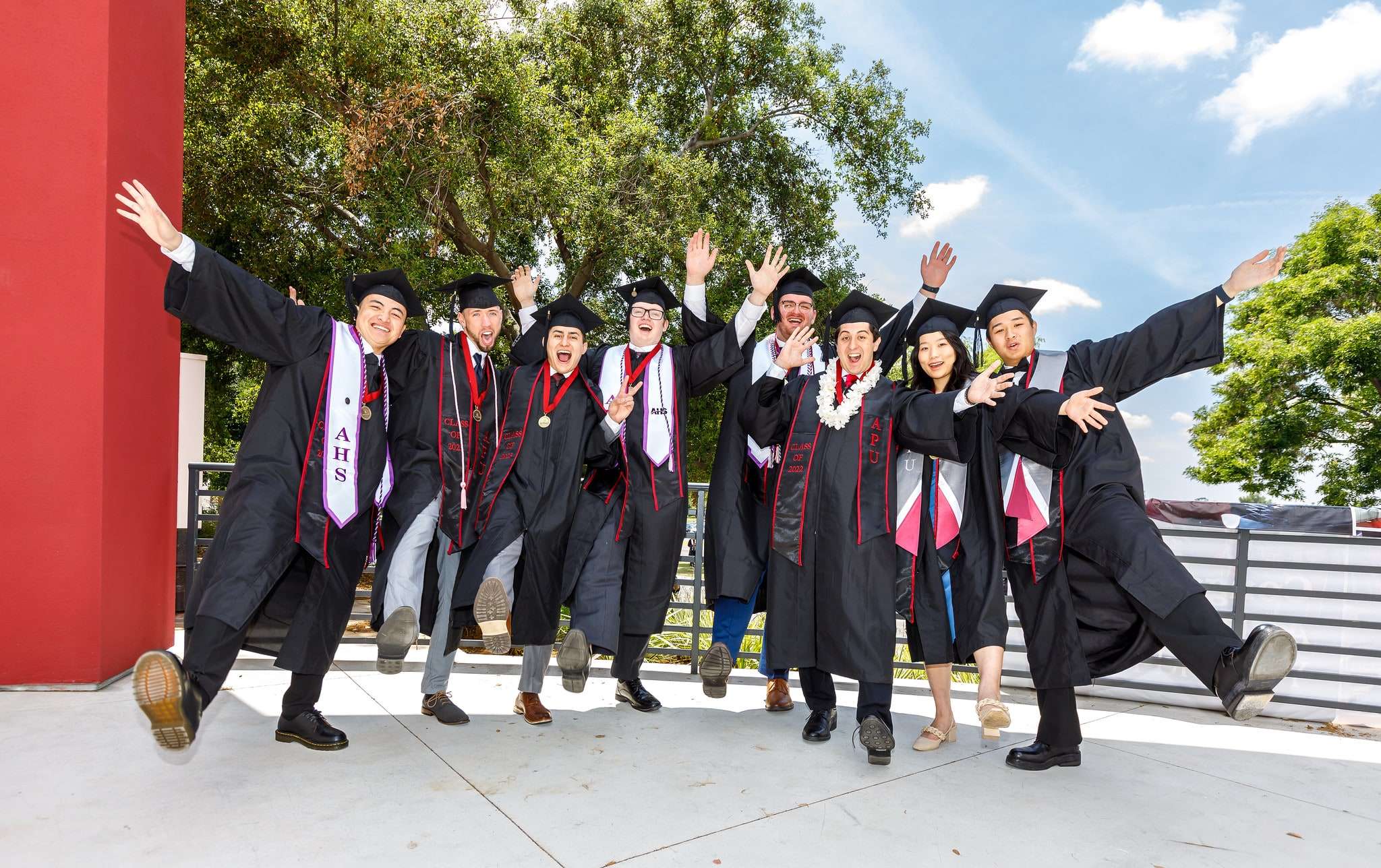 students celebrating their graduation wearing cap and gown