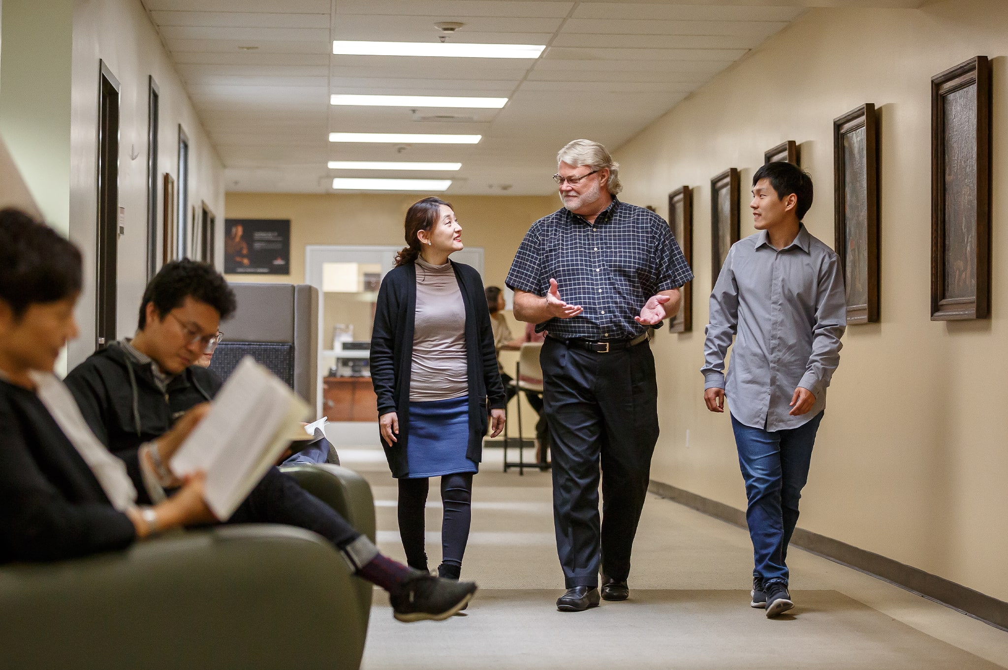 students and professor talking in a hallway