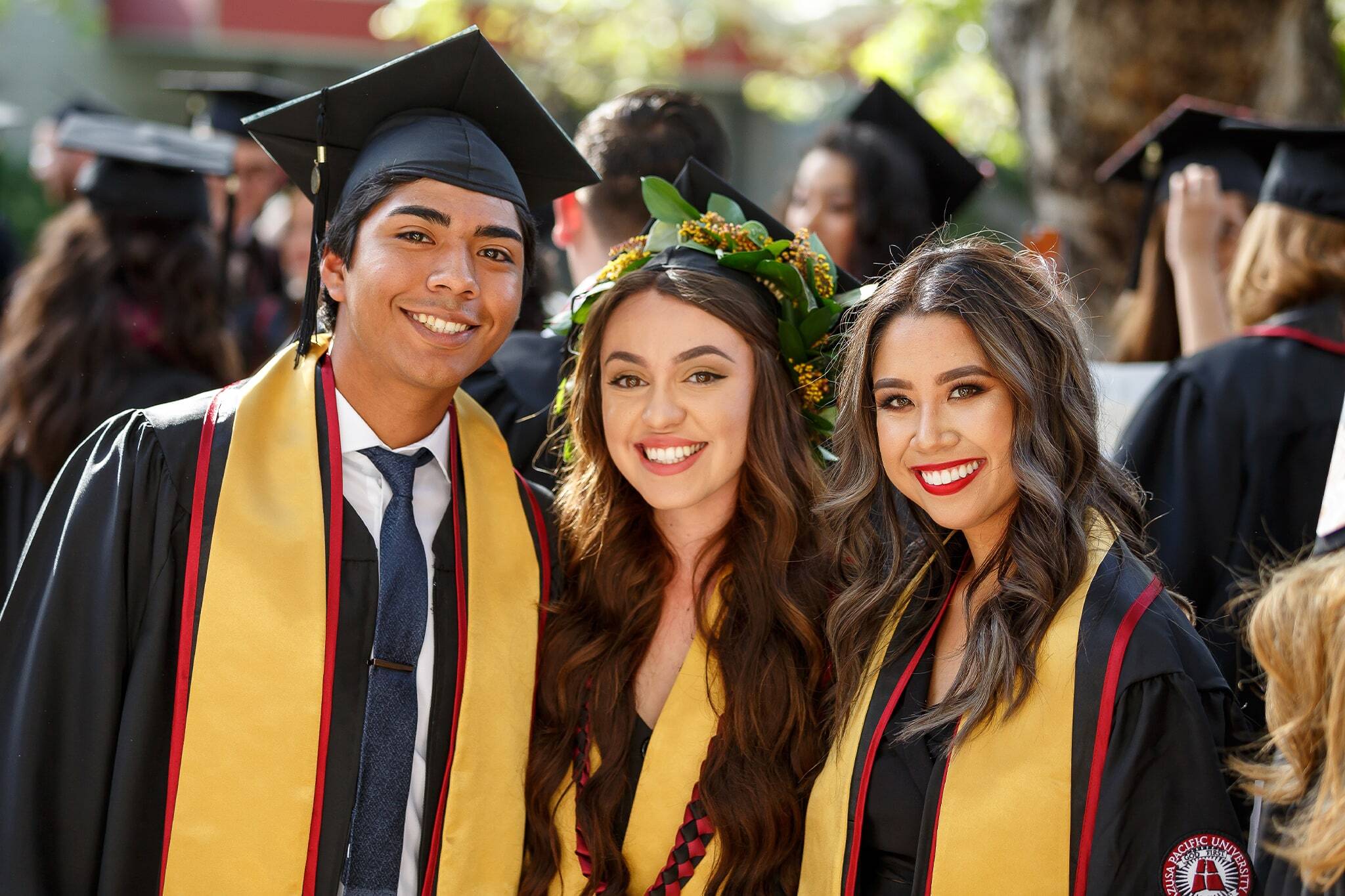 apu students during commencement ceremony smiling and wearing their cap and gown