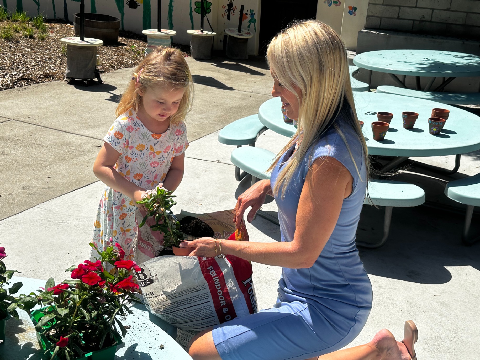 Amy Alzina works with one of her elementary students on a plant for the school's garden