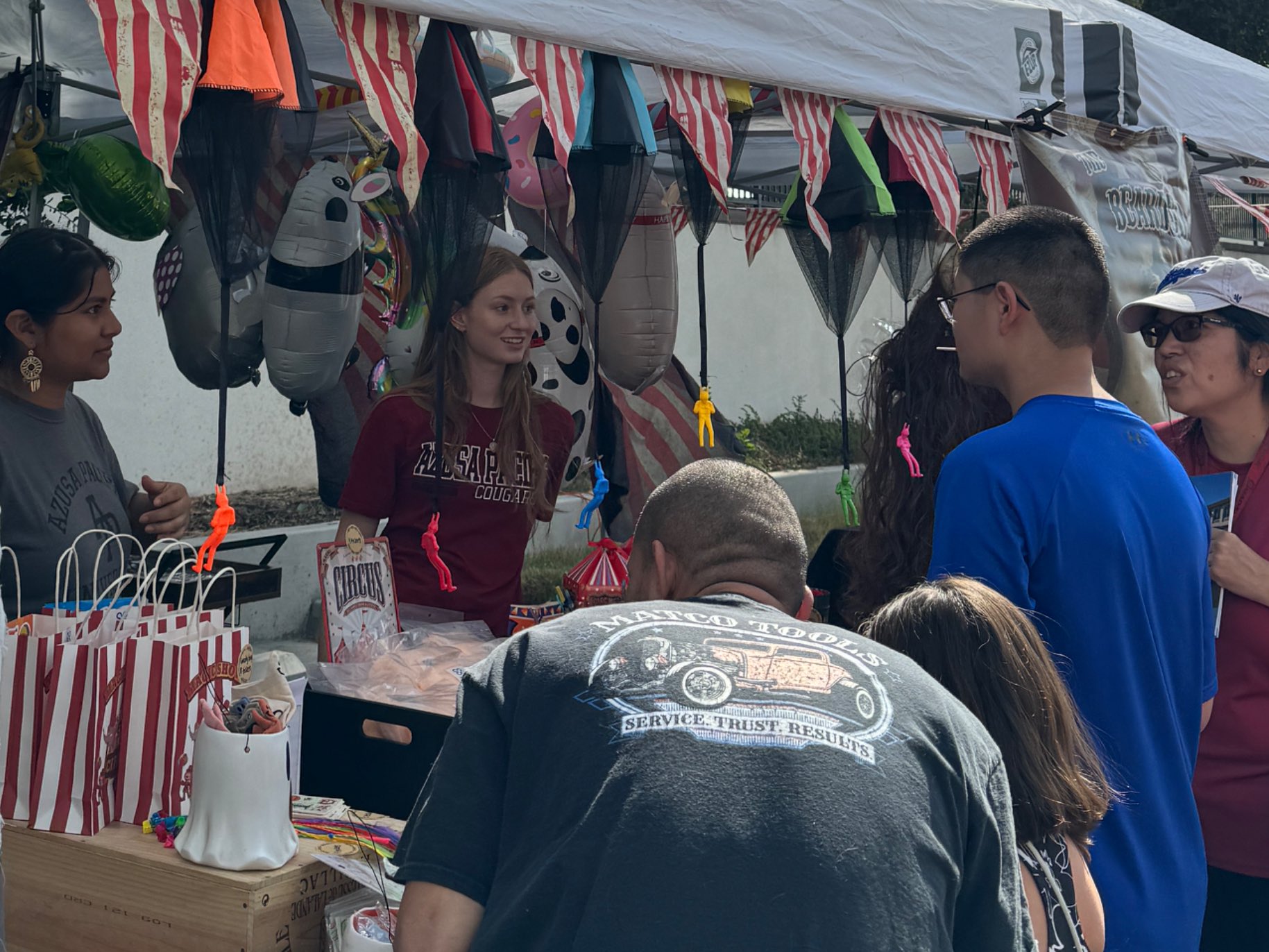 Carnival attendees stop by a booth run by APU students.