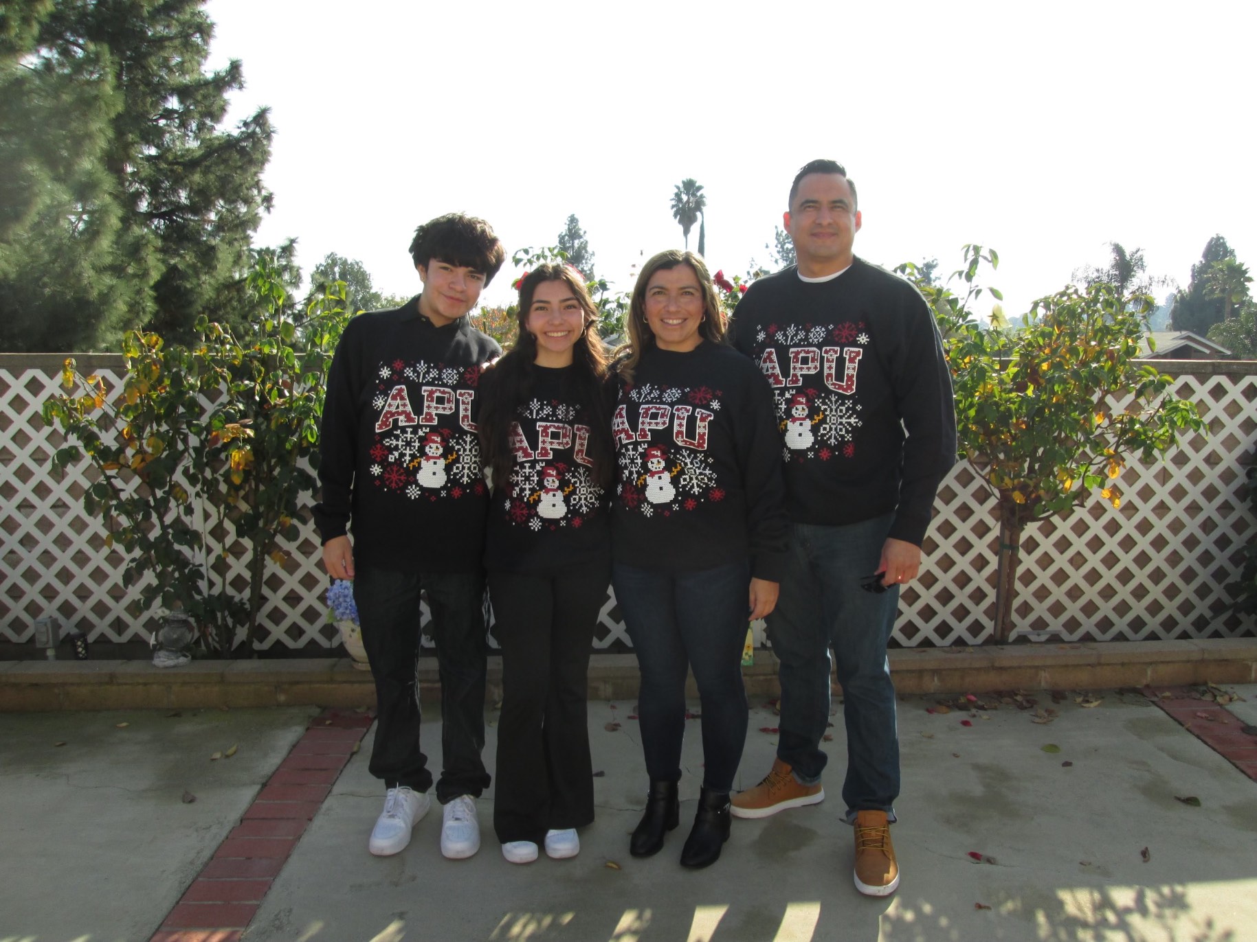 Danielle Lascano stands outside with her family wearing matching APU sweatshirts.