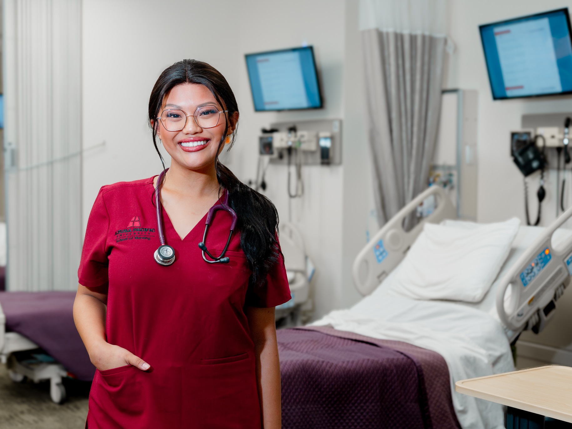 A nursing student poses in a clinical classroom