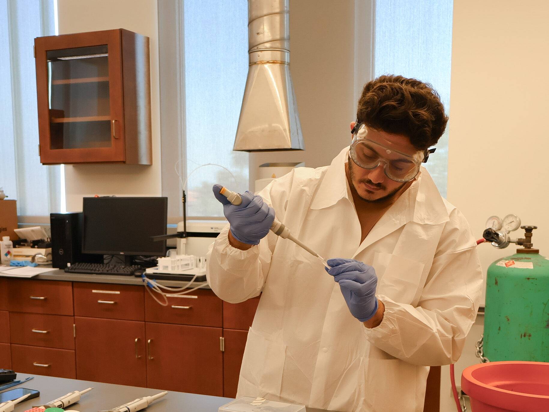 A biochemistry student conducts an experiment.