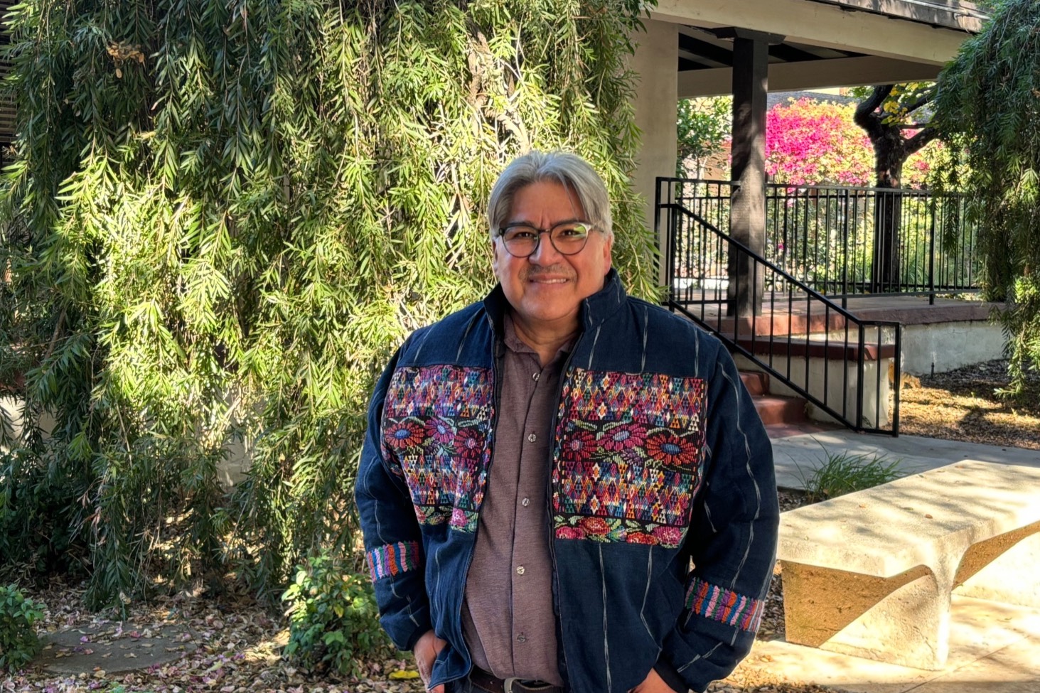 cesar smiles outside the rose garden on a sunny day