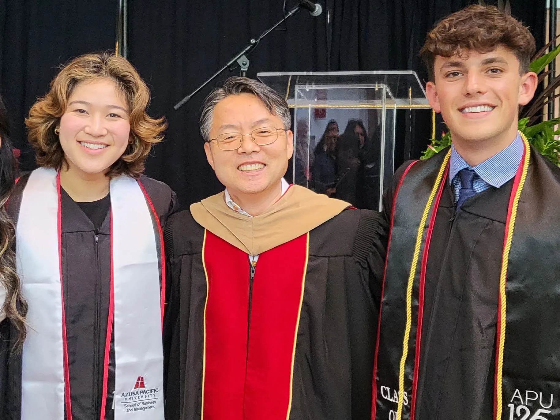 Daniel Park stands with two of his students at commencement.