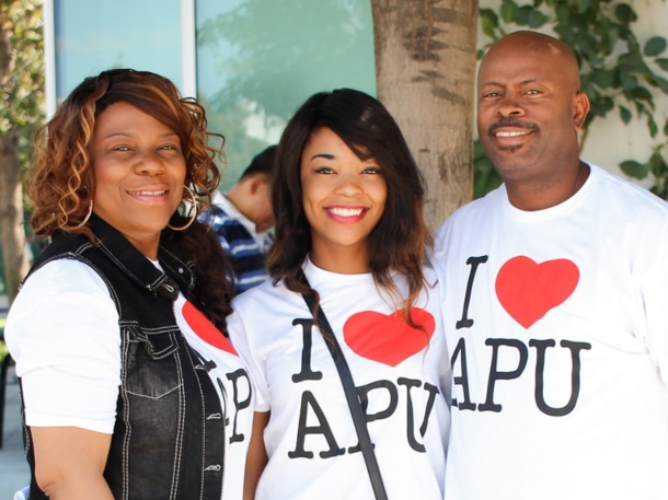 a family smiling wearing apu white t-shirts