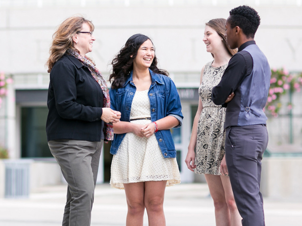 students and professor talking in front of Darling Library on west campus