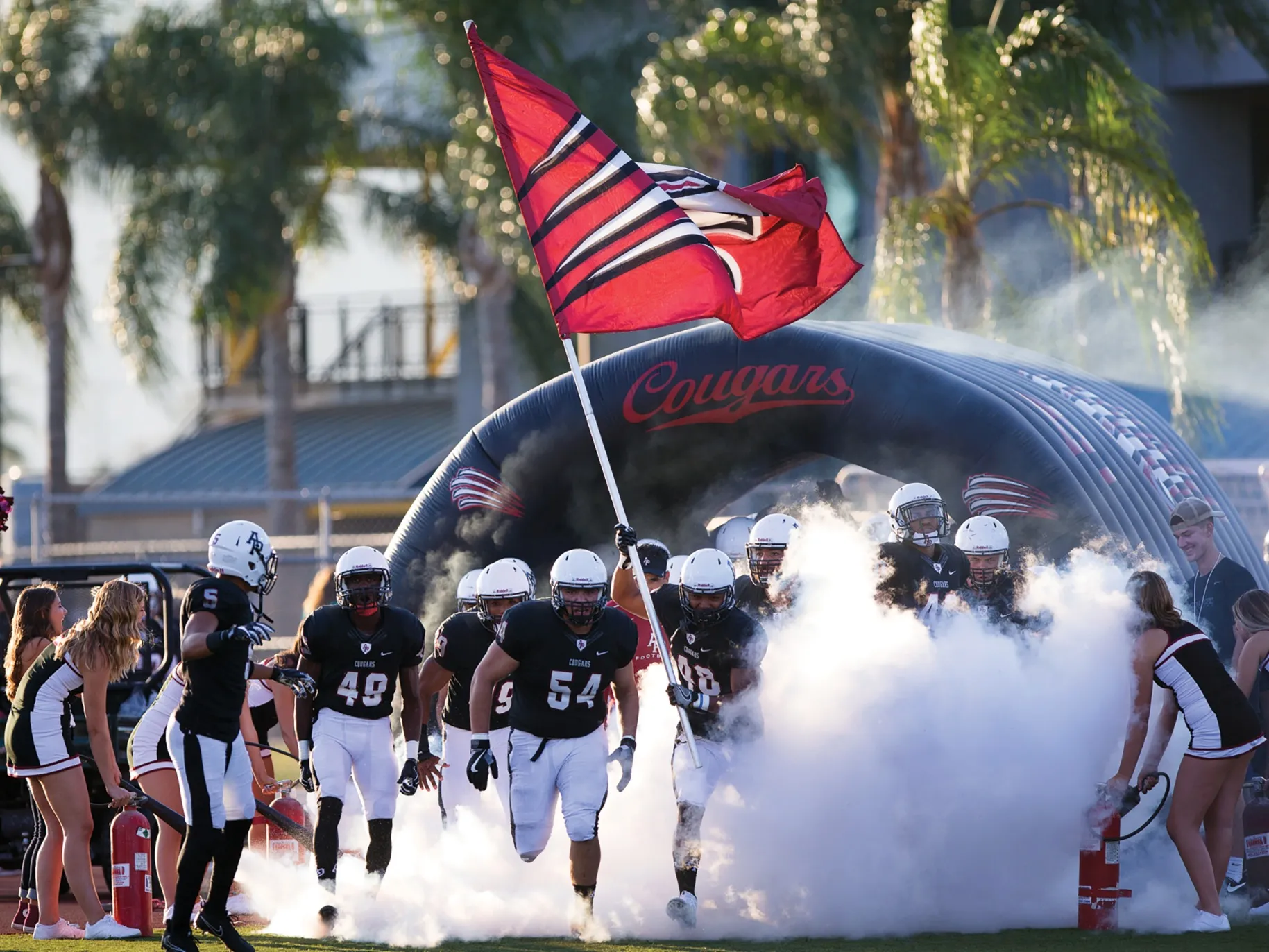 APU football players rush onto the field.