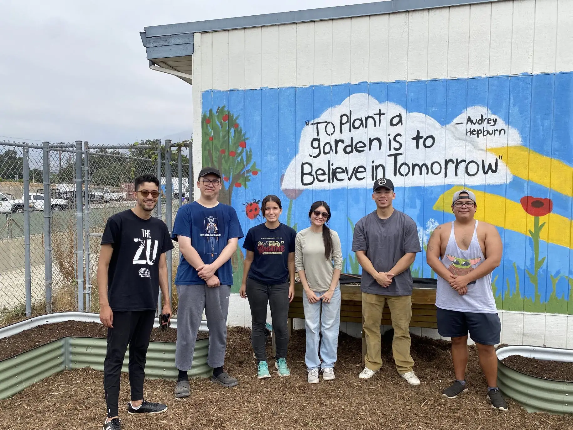 Volunteers stand outside near planter beds on Green Care Day.