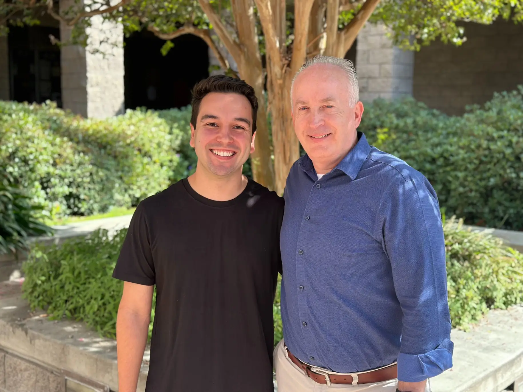 Matt Elofson and Will Johnston smile together in front of Munson Chapel