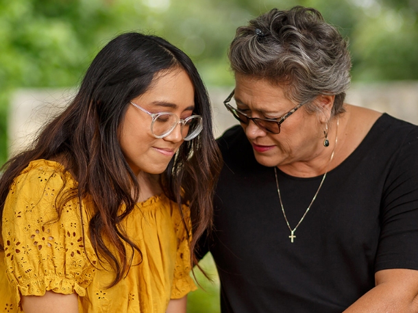 student praying with her mom