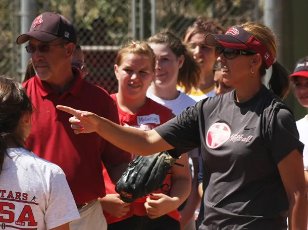 Athletic coach teaching students how to play softball