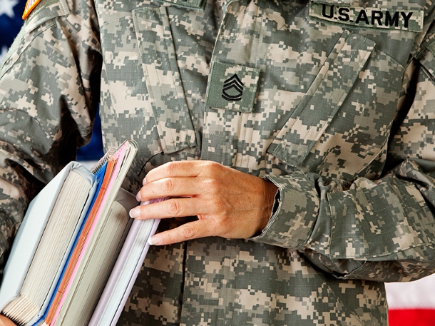 person wearing U.S Army gear holding some books