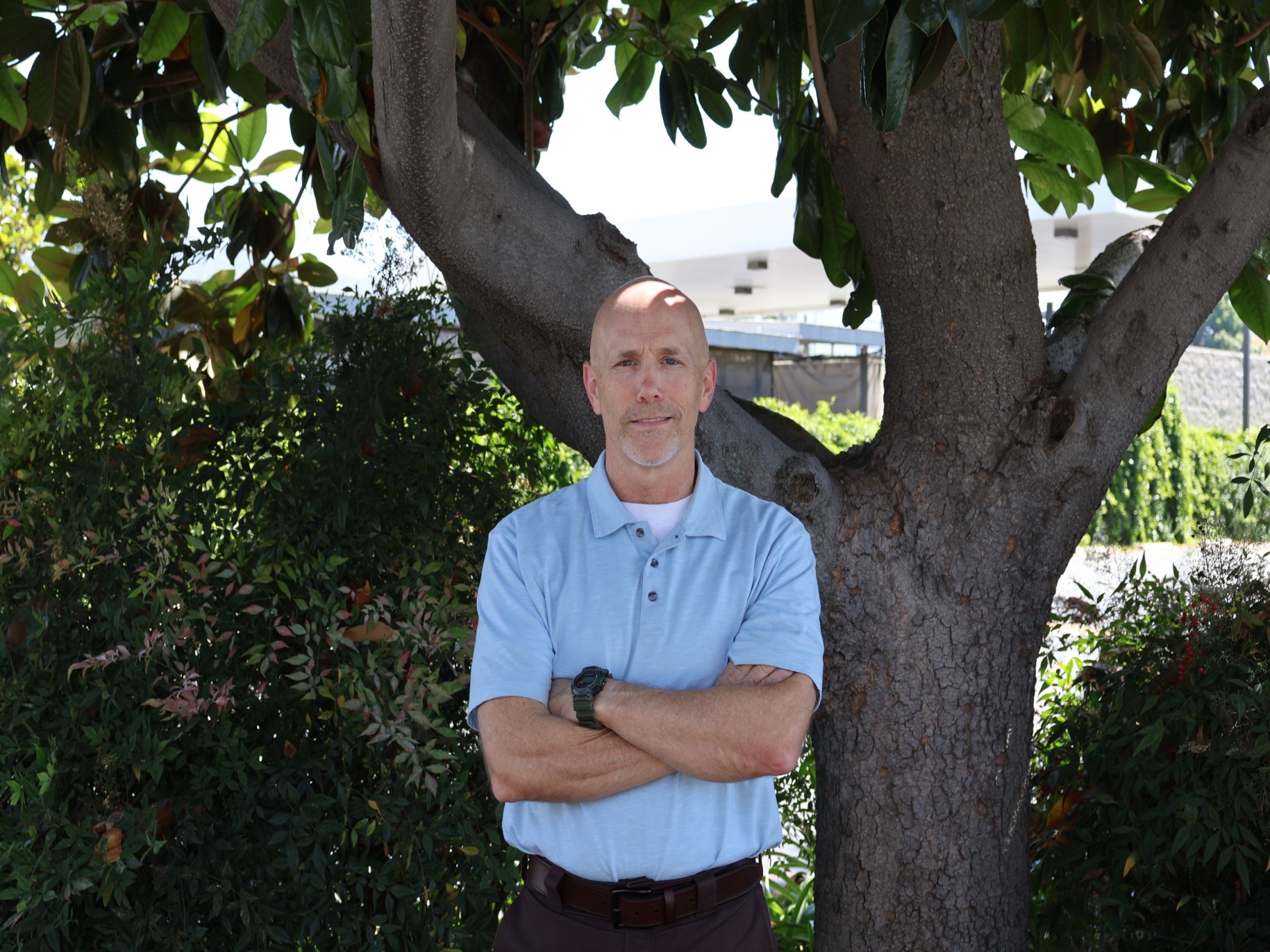 Todd smiles outside a tree near the student health center