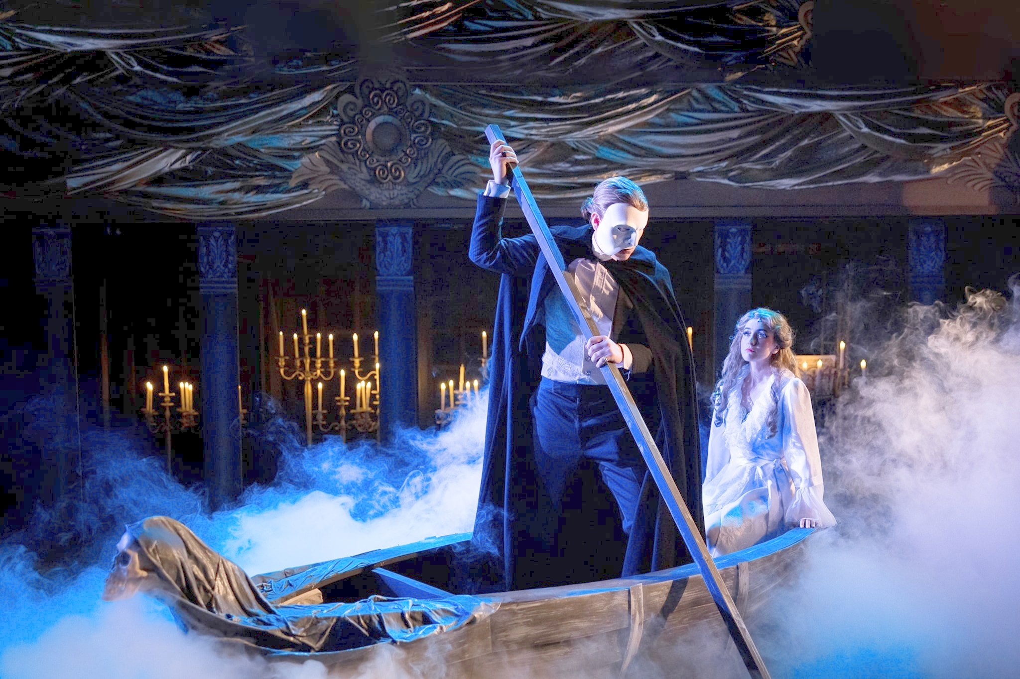 Phantom of the opera rowing a boat on stage