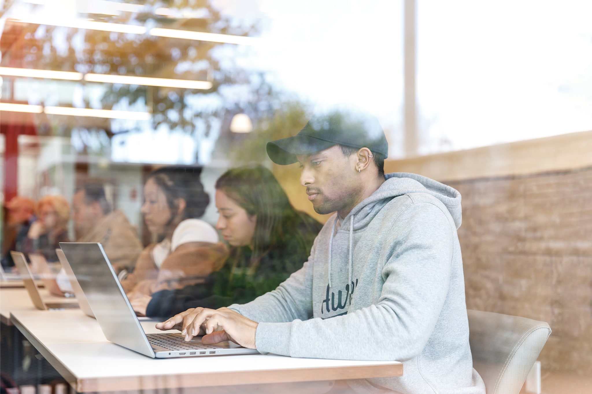 Student work on computer pictured through glass window