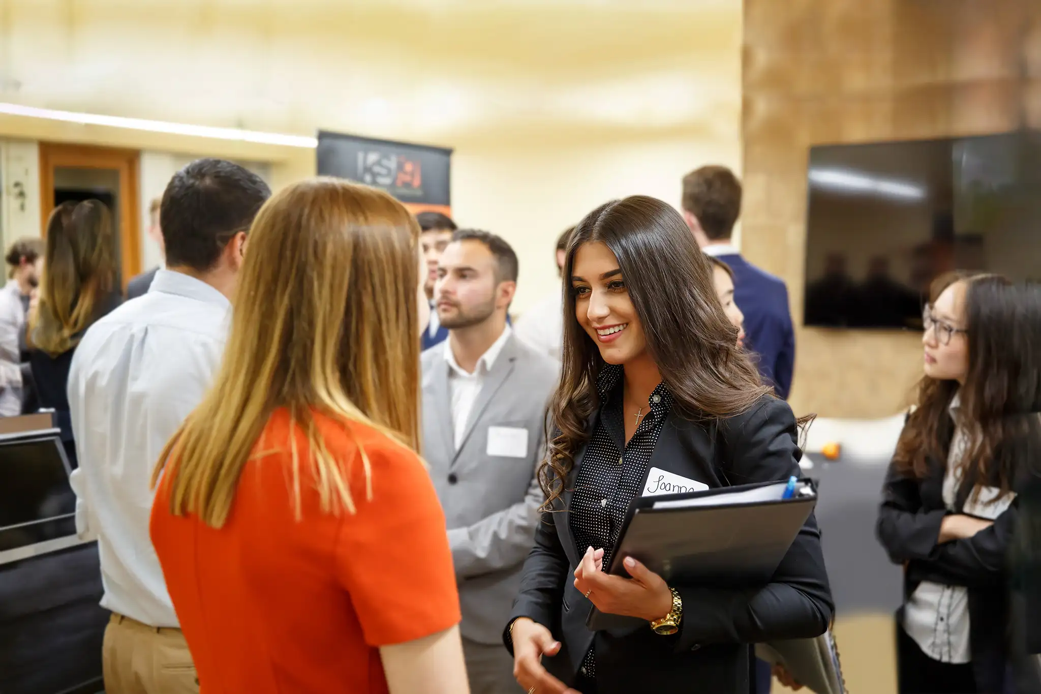 woman student wearing a suit and talking to a woman