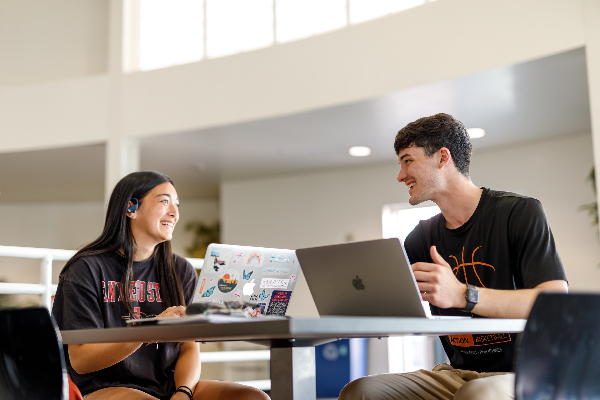 2 students talking and studying together