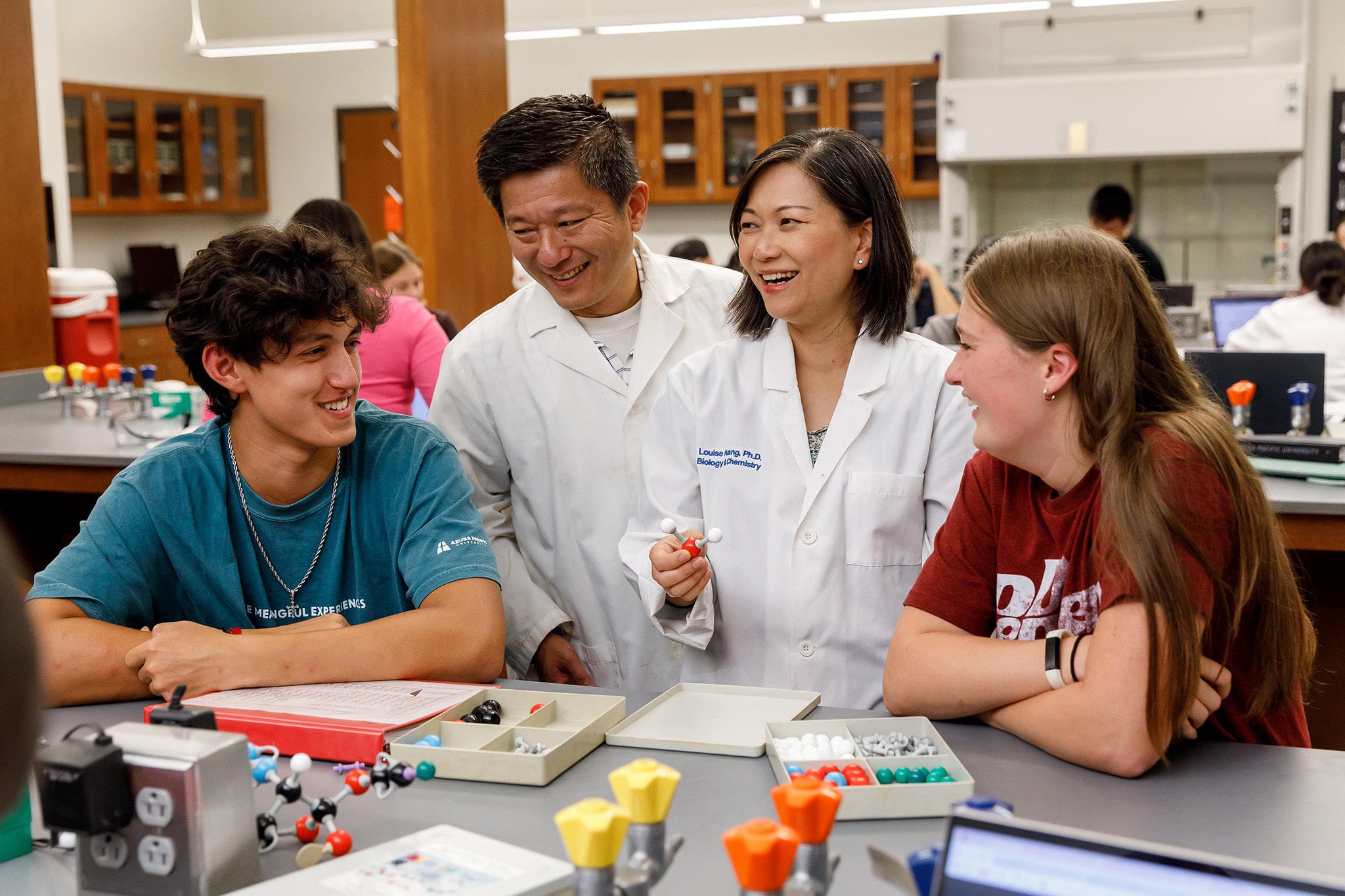 Mr. and Mrs. Huang teaching students in a lab
