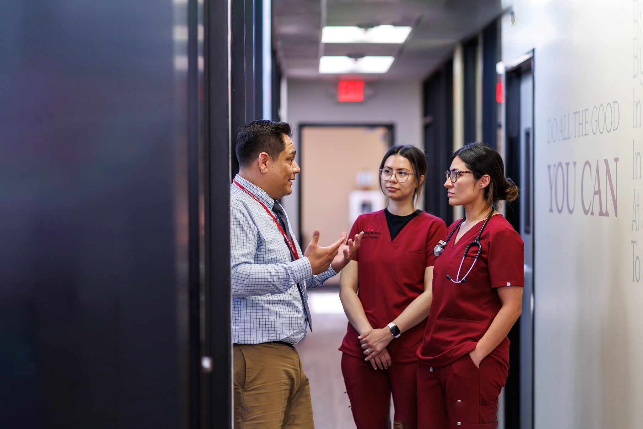 2 nursing students speaking with a professor