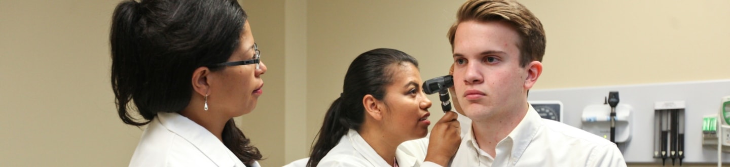 Nursing students inspecting ear