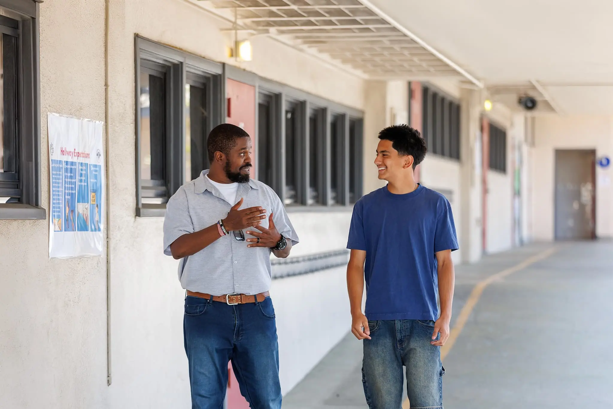 students smiling while professor is talking to him