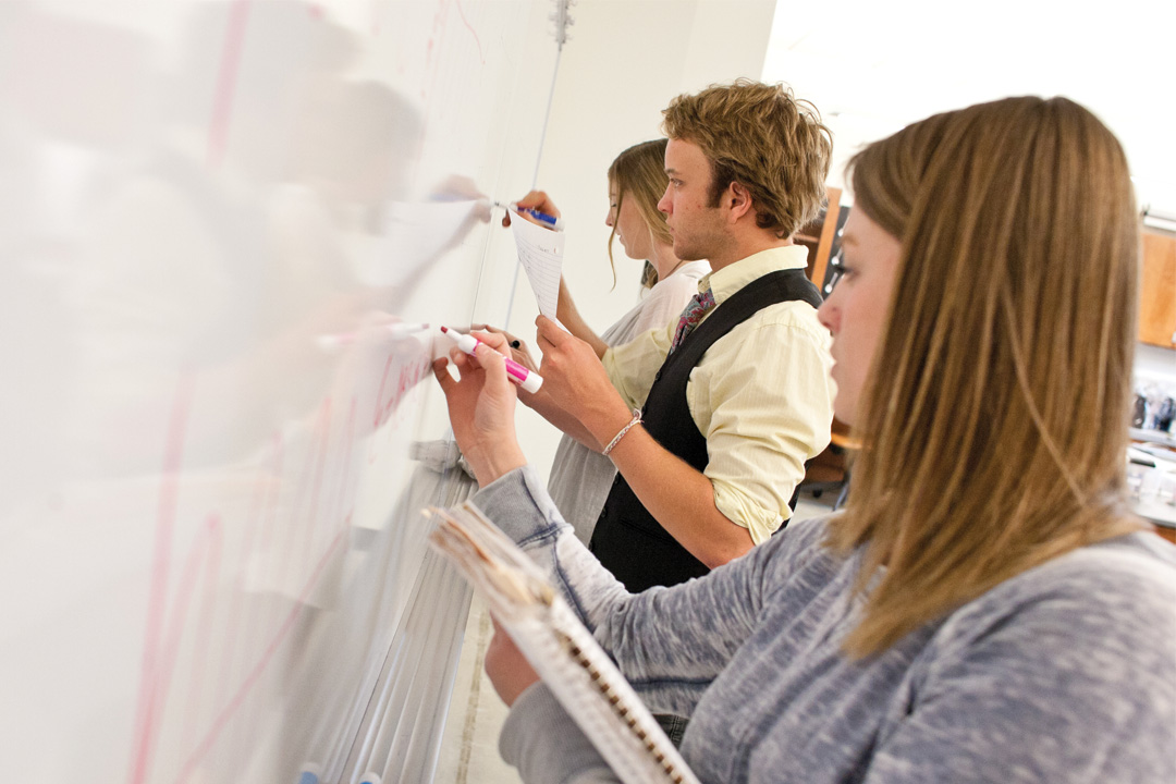 Students writing on whiteboard