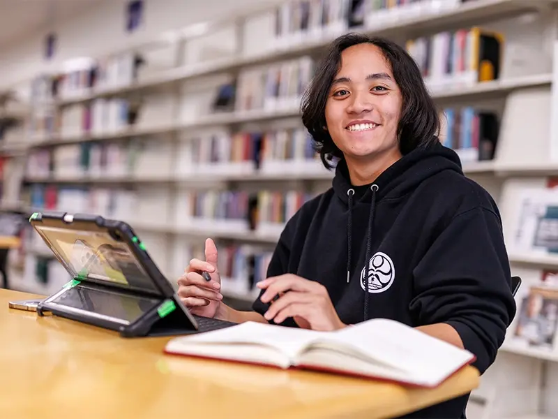 apu student smiling at the library wearing a black hoodie