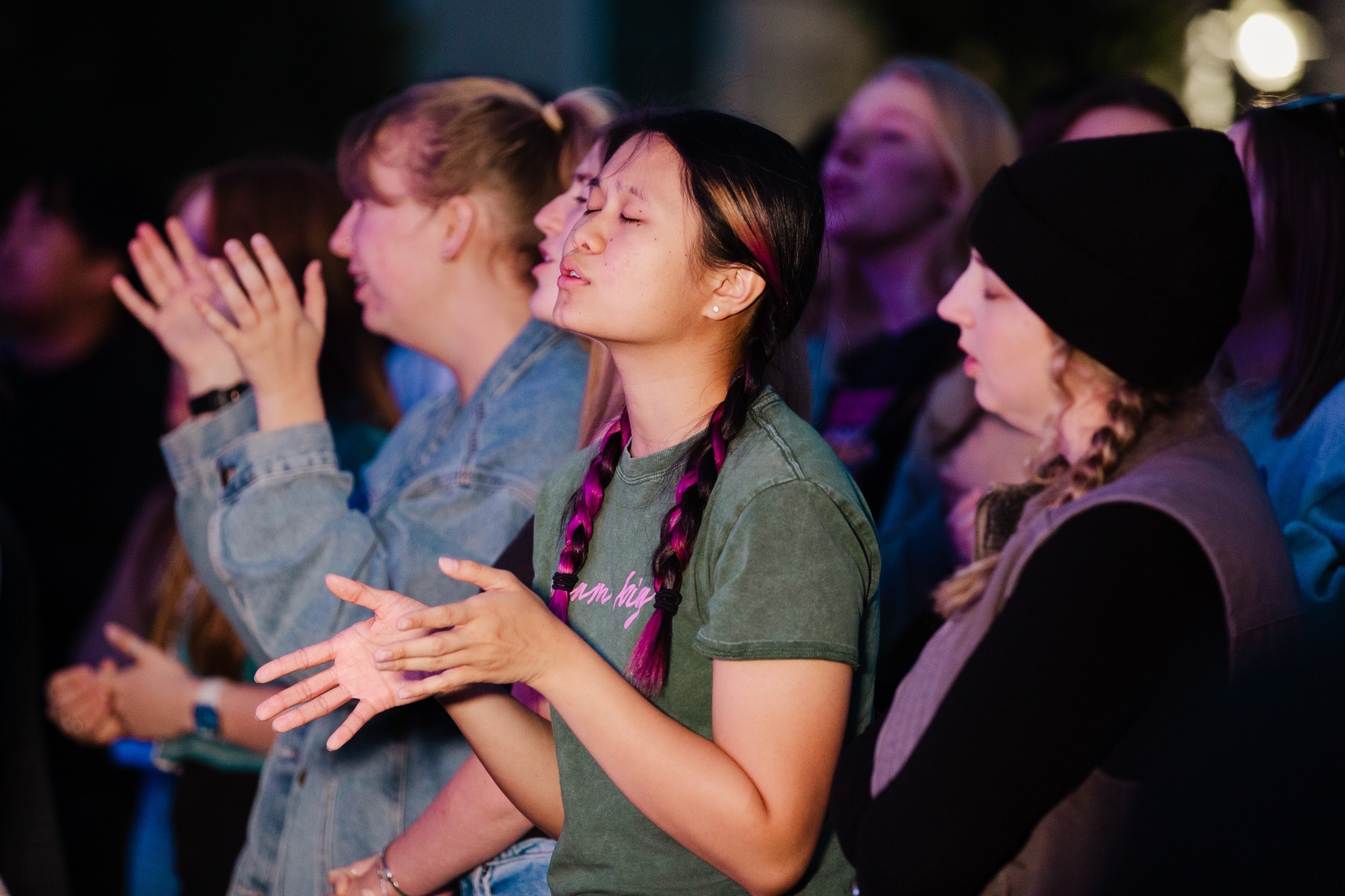 Student worshipping with eyes closed