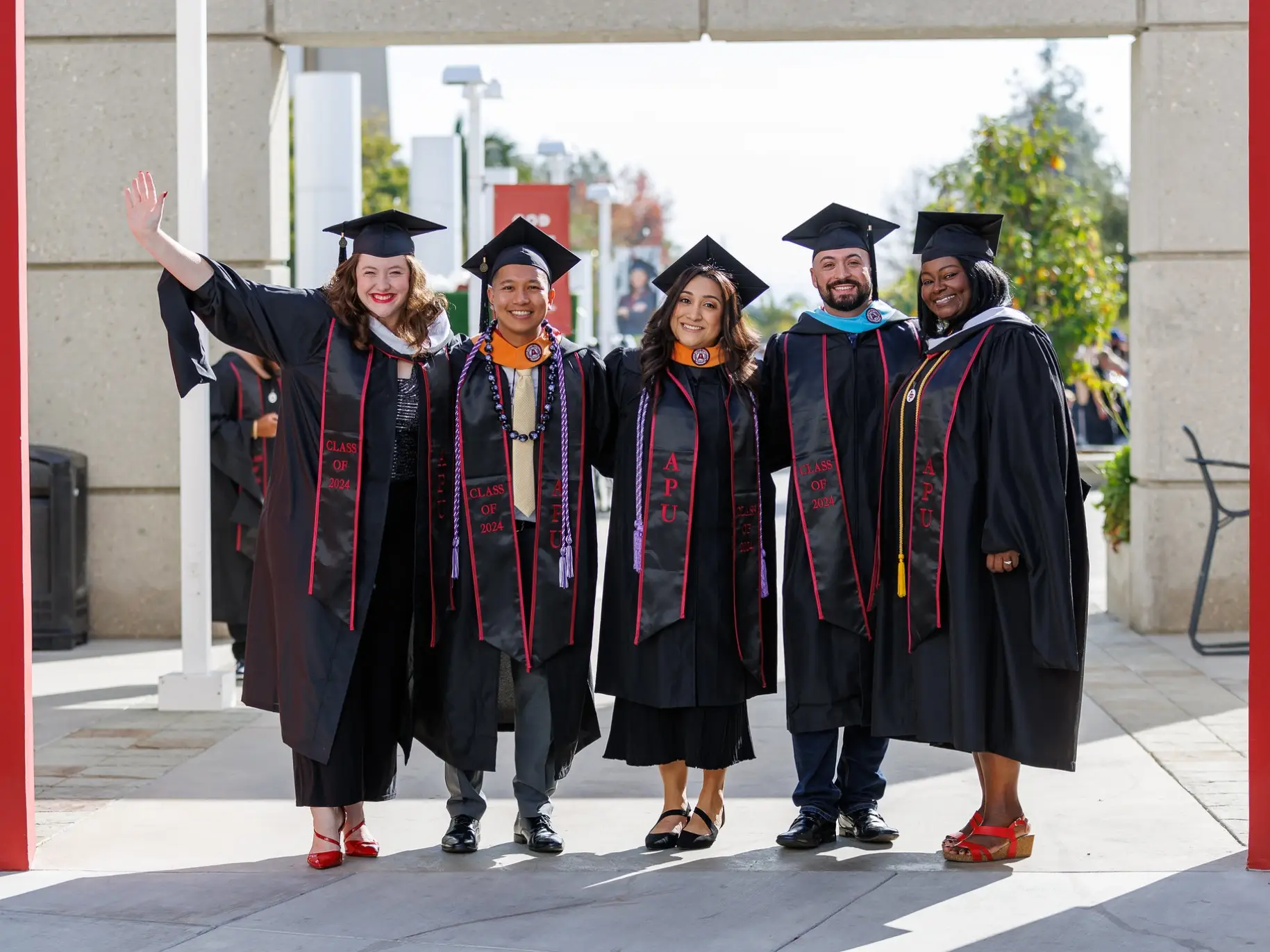 A group of graduating students smile at commencement